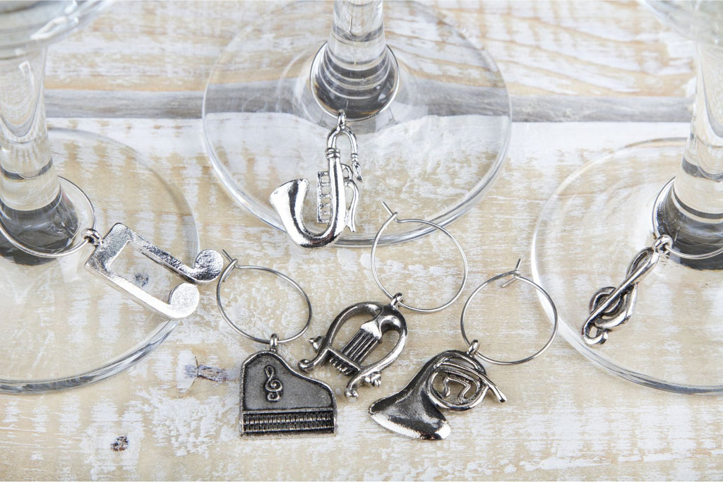 Three wine glasses on cloth, with charms in between all of them. Occasional Paper Cuts