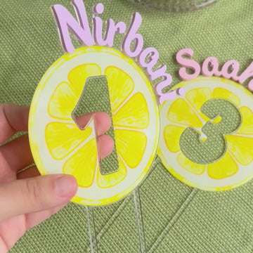 video showing reflective lemon cake toppers with cutout number and name